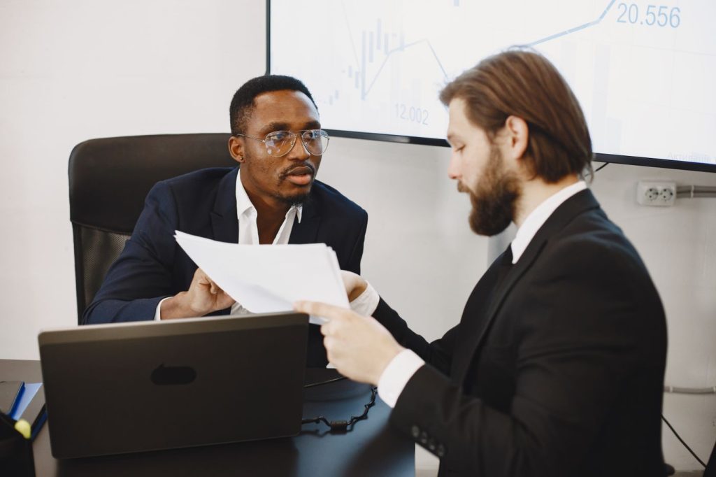 Business broker and prospective buyer reviewing acquisition documents